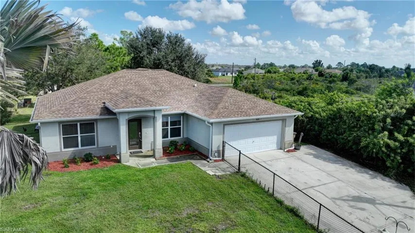 Single-story residence featuring a shingle roof, attached garage with a white door, and a concrete driveway
