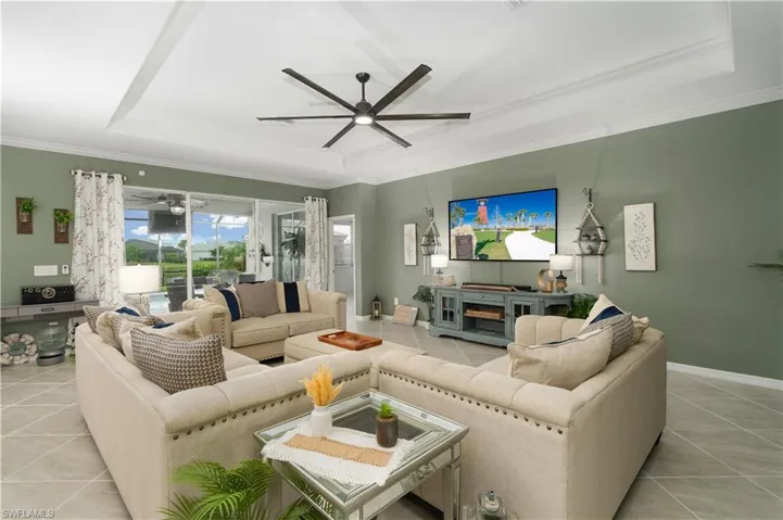 Open Concept Style Living with tray ceiling, tile flooring and crown molding