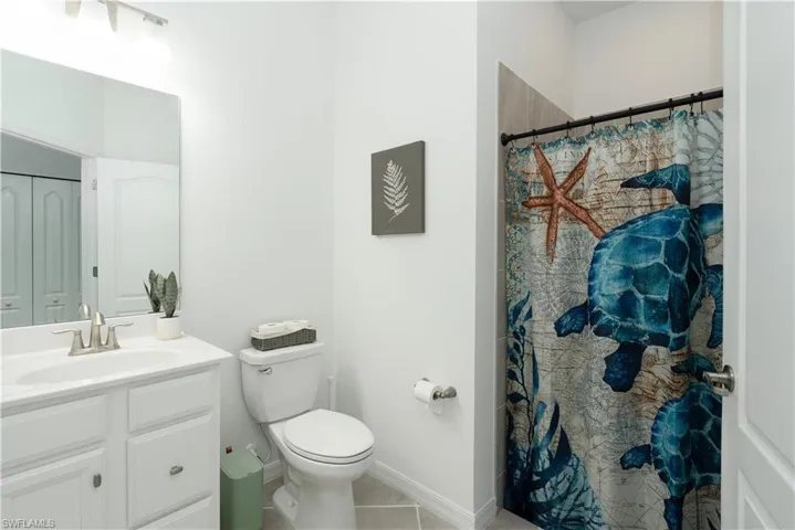 Fully tiled shower with small step down into shower.
