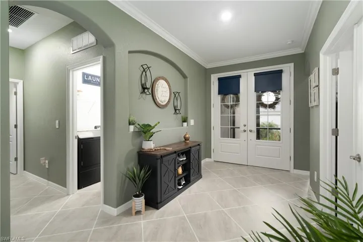 Tiled foyer with french doors, crown molding, top of the line SW Emererld Paint