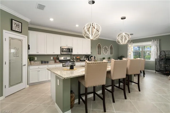 White Kitchen Cabinetry, tile flooring with MASSIVE center island (upgraded Pantry door too)