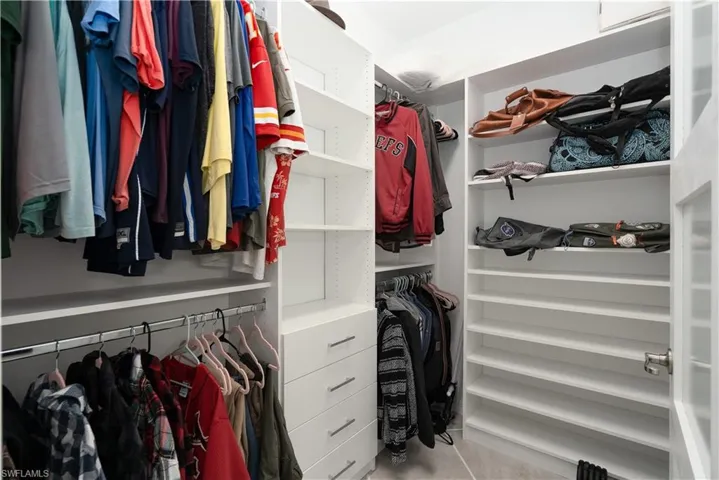 Walk in closet featuring custom closet system by Florida Closets and More