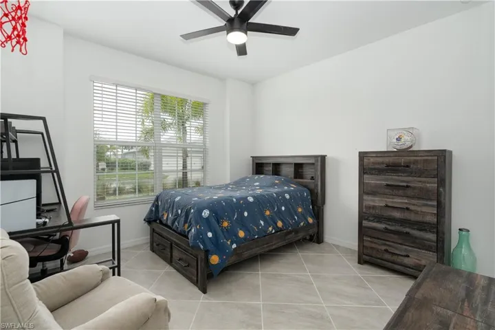 Guest Bedroom with ceiling fan and light tile flooring