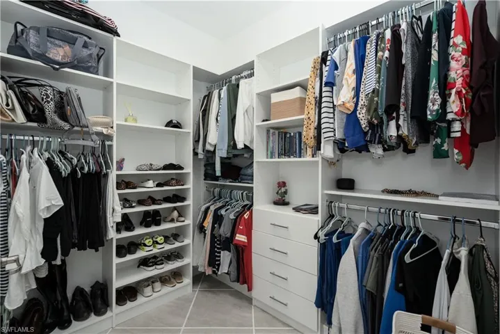 Walk in closet featuring custom closet system by Florida Closets and More