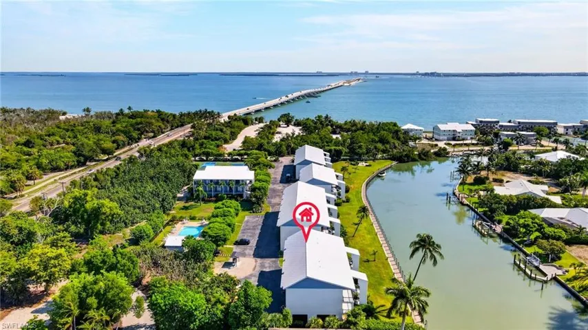 Coastal property featuring direct canal access, a community swimming pool, and proximity to a major bridge