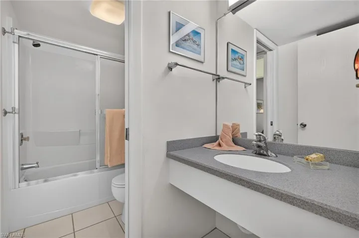 Bathroom featuring a built-in vanity with a speckled countertop and an integrated sink
