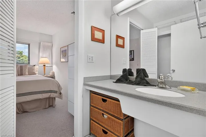 Bathroom vanity featuring a solid surface countertop with integrated sink and chrome faucet