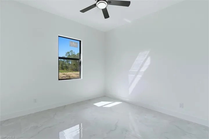 Spare room with baseboards and a ceiling fan