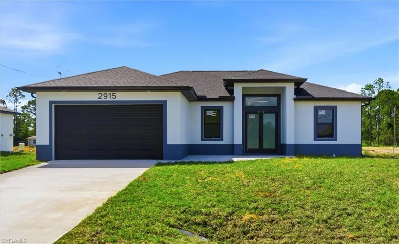 Prairie-style house featuring an attached garage, driveway, stucco siding, a front lawn, and a shingled roof