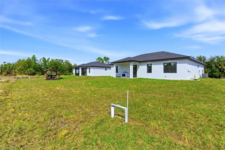 Rear view of property featuring stucco siding and a yard