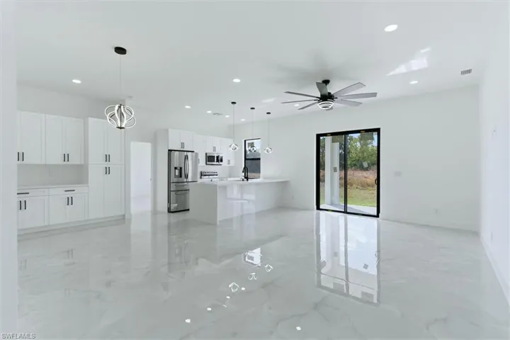 Unfurnished living room with recessed lighting, ceiling fan, and light marble finish flooring