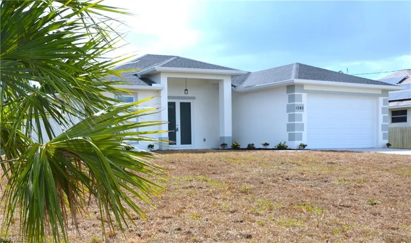 View of front of property side with a garage, and a front lawn.