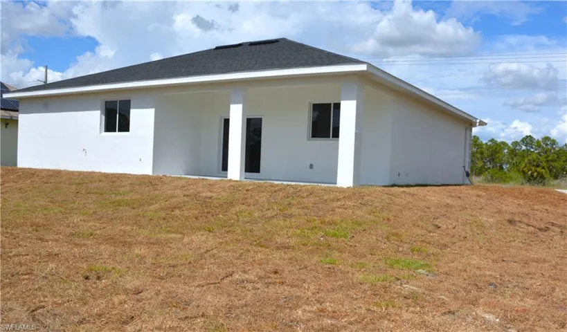 Rear view of house featuring a lawn