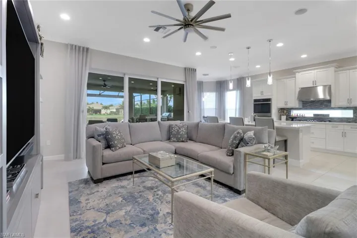 Living room featuring light tile patterned floors and ceiling fan