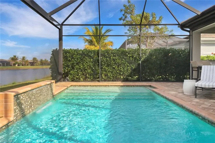 View of pool with a lanai, a patio, and a water view