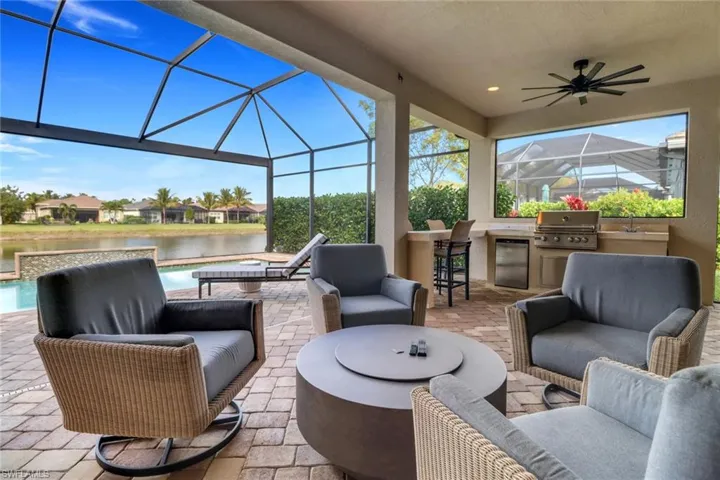 View of patio / terrace with an outdoor kitchen, a wet bar, a water view, area for grilling, and an outdoor living space