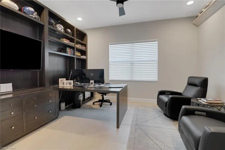 Office area featuring light tile patterned floors and ceiling fan