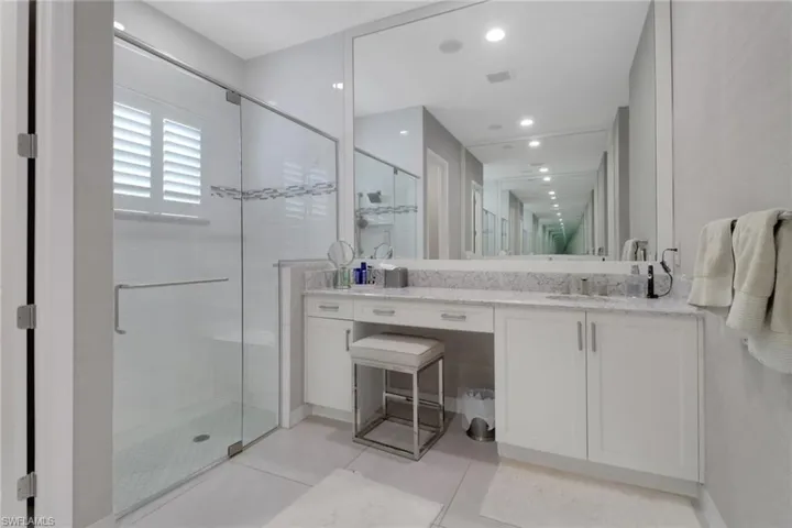 Bathroom with an enclosed shower, vanity, and tile patterned floors