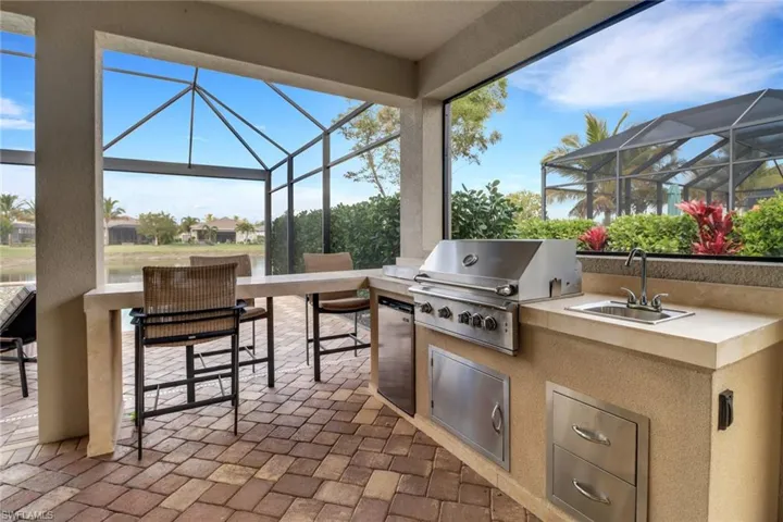View of patio featuring a grill, exterior kitchen, and an outdoor wet bar