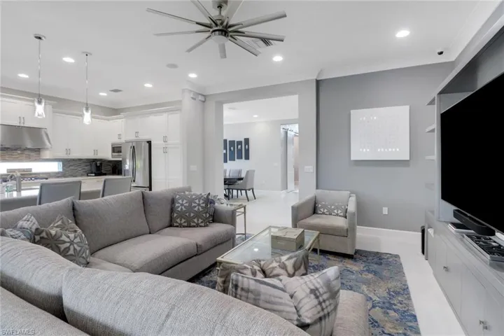 Tiled living room featuring ornamental molding and ceiling fan