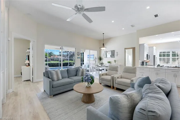 Spacious living area featuring high vaulted ceilings, light wood-finish flooring, and recessed lighting.