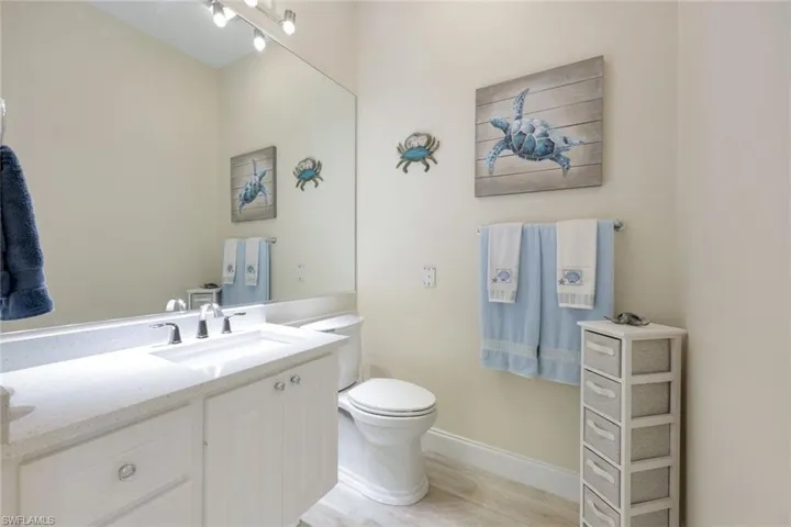 Bathroom featuring a white vanity with a light-colored countertop, an undermount sink, and a chrome faucet.