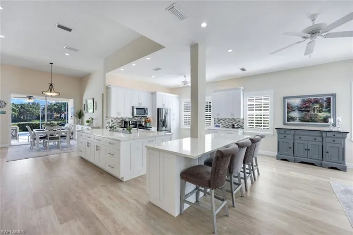 Open-concept kitchen and sitting area with light wood-finish flooring