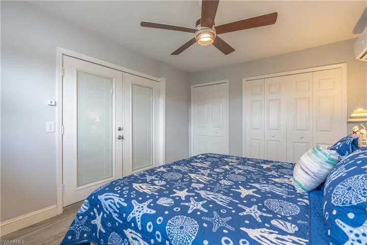 Bedroom featuring wood finished floors, multiple closets, and ceiling fan