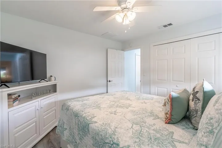 Bedroom with a ceiling fan, a closet, and dark wood finished floors