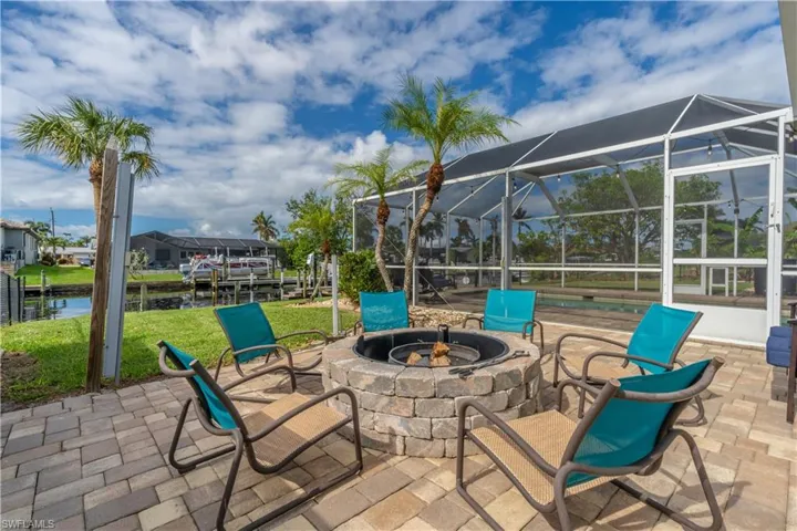 View of patio / terrace featuring a lanai, a fire pit, a sunroom, and a water view