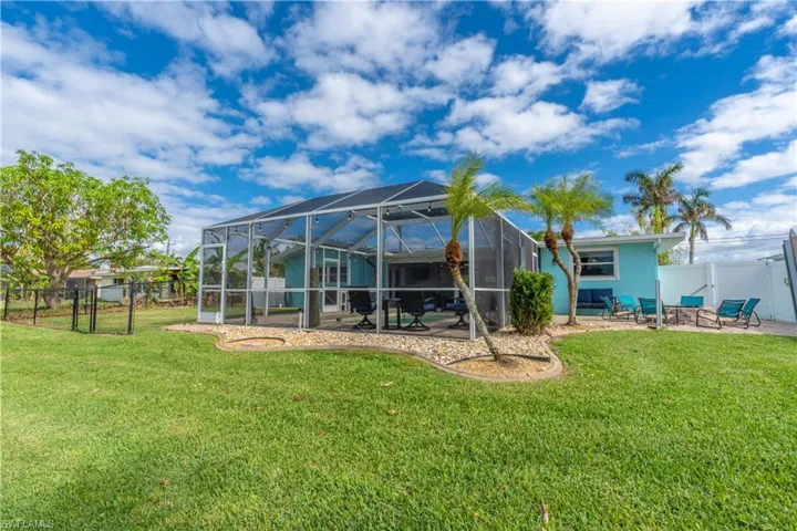 Rear view of house with a patio area, a fenced backyard, a gate, and a lanai