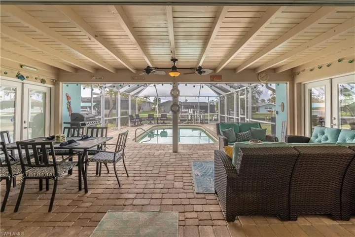 Sunroom / solarium with french doors, outdoor dining area, an outdoor living space, a patio, and beam ceiling