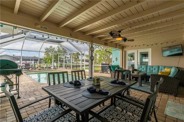 View of patio / terrace featuring a lanai, a sunroom, outdoor lounge area, ceiling fan, and an outdoor pool