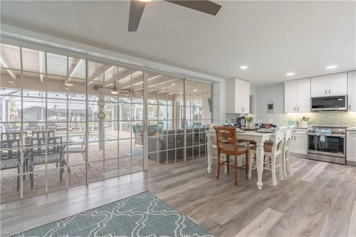 Dining area featuring light wood-style flooring, a ceiling fan, and a textured ceiling