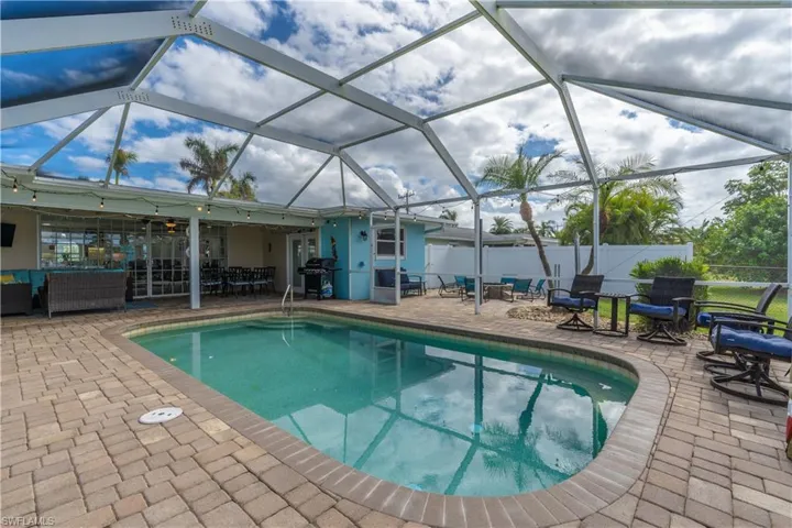 Swimming pool with glass enclosure, an outdoor hangout area, a sunroom, and area for grilling