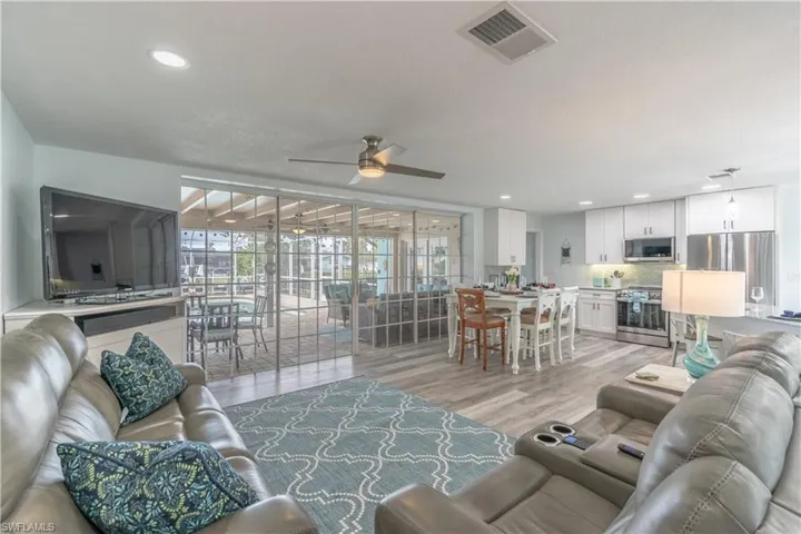 Living area with light wood-style floors, recessed lighting, and a ceiling fan
