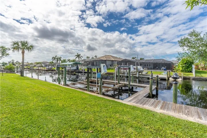 Dock with a yard, a residential view, and boat lift