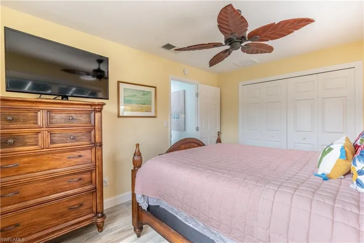 Bedroom featuring light wood finished floors, a ceiling fan, and a closet