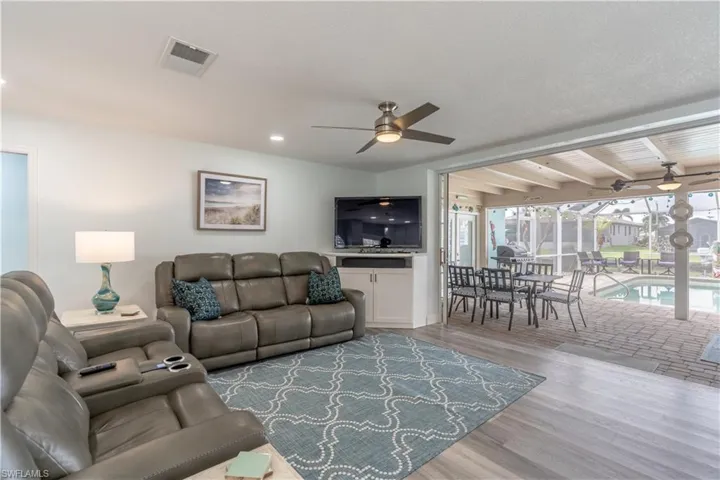 Living area featuring a sunroom, wood finished floors, and ceiling fan