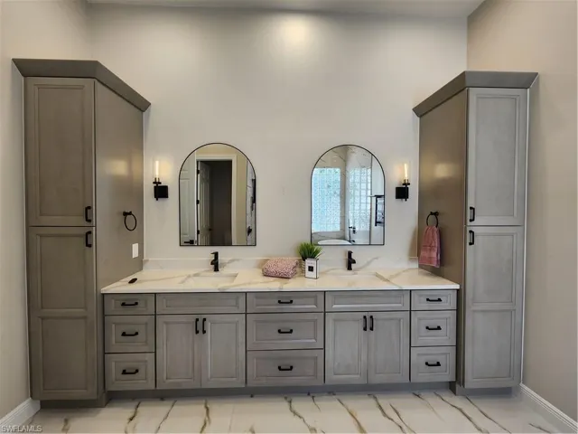 Full bathroom with baseboards and double vanity