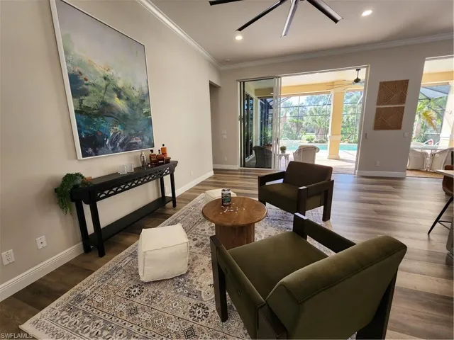Living area featuring dark wood-style floors, ceiling fan, recessed lighting, and ornamental molding