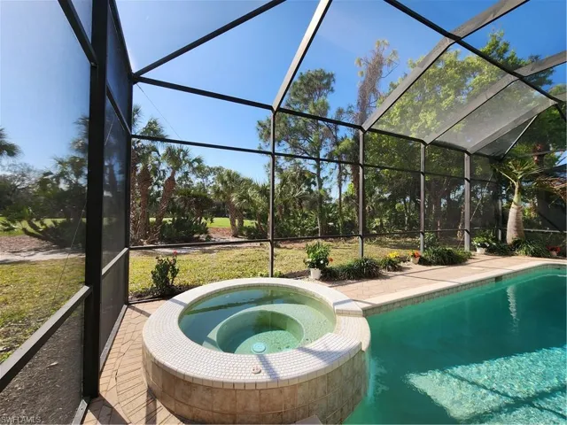 Integrated pool / spa featuring a sunroom, a lanai, and a patio