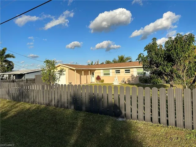 View of front of property with stucco siding, a fenced front yard, and a front yard