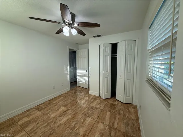 Unfurnished bedroom with a closet, visible vents, a ceiling fan, a textured ceiling, and baseboards