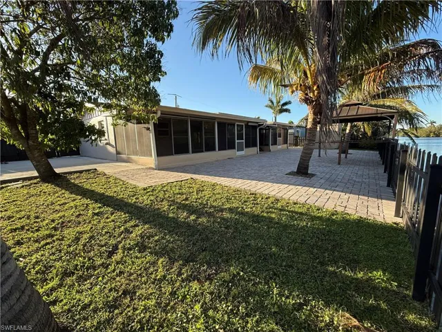 View of yard with a sunroom, a patio area, fence, and a gazebo