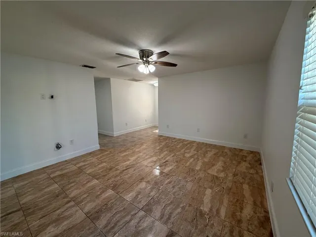 Spare room featuring baseboards, a textured ceiling, visible vents, and a ceiling fan