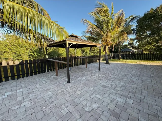 View of property's community with a patio area, a fenced backyard, and a gazebo