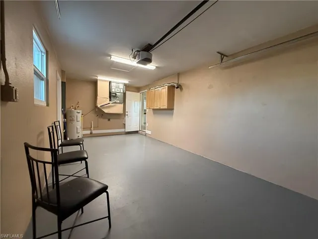 Garage with a garage door opener, water heater, and heating unit
