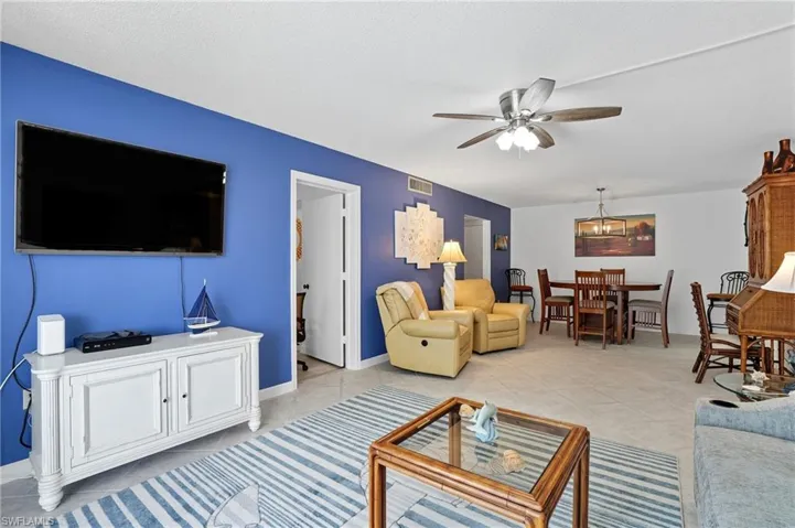 Open-concept living area featuring light tile flooring and a ceiling fan