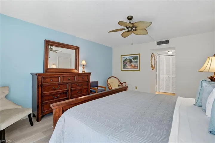 Spacious room featuring wood-finish flooring, a ceiling fan, and bi-fold closet doors